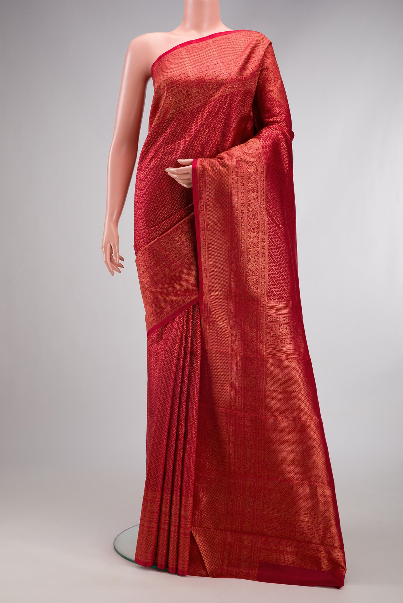 Red Kanjivaram Silk Saree with Zari Brocade on the body and Fancy Border.  displayed on a mannequin