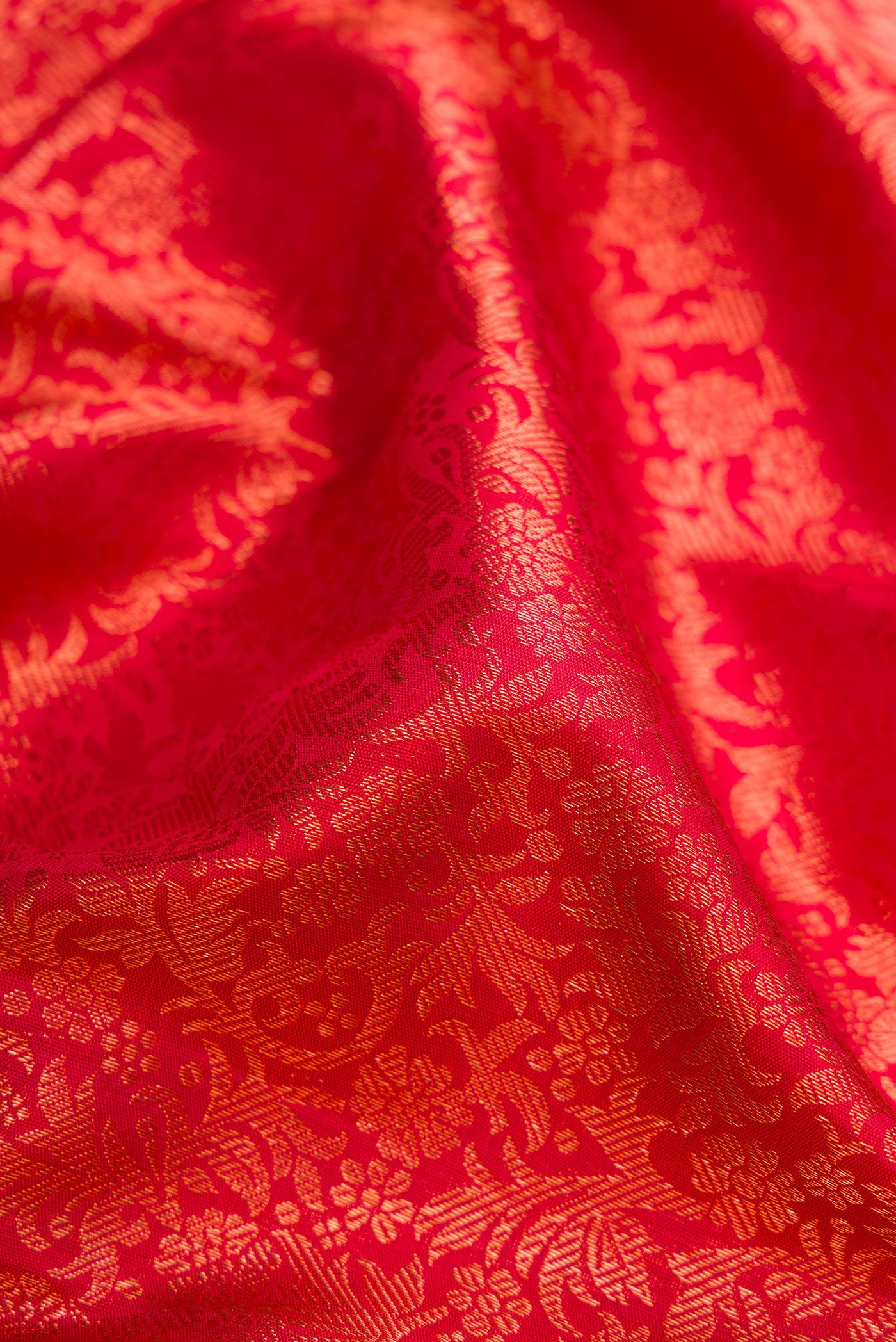 Close up of Red Dual Tone Kanjivaram Silk Saree with Zari Brocade on the body and Zari Border.  displaying folds