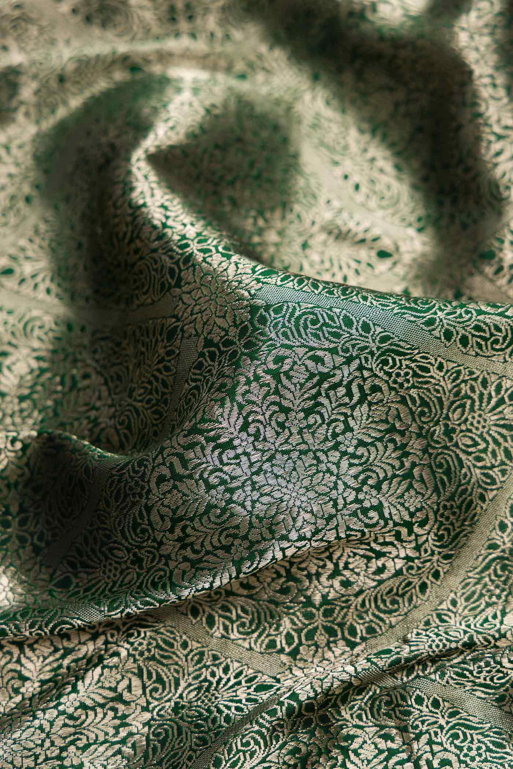 Close up of Bottle Green Dual Tone Banarasi Silk Saree with Zari Brocade on the body and Zari Border.  displaying folds