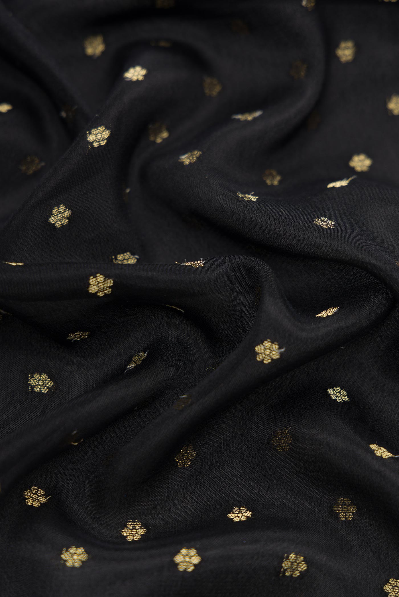 Close up of Black Dual Tone Mysore Crepe Saree with Zari Butta on the body and Fancy Border.  displaying folds