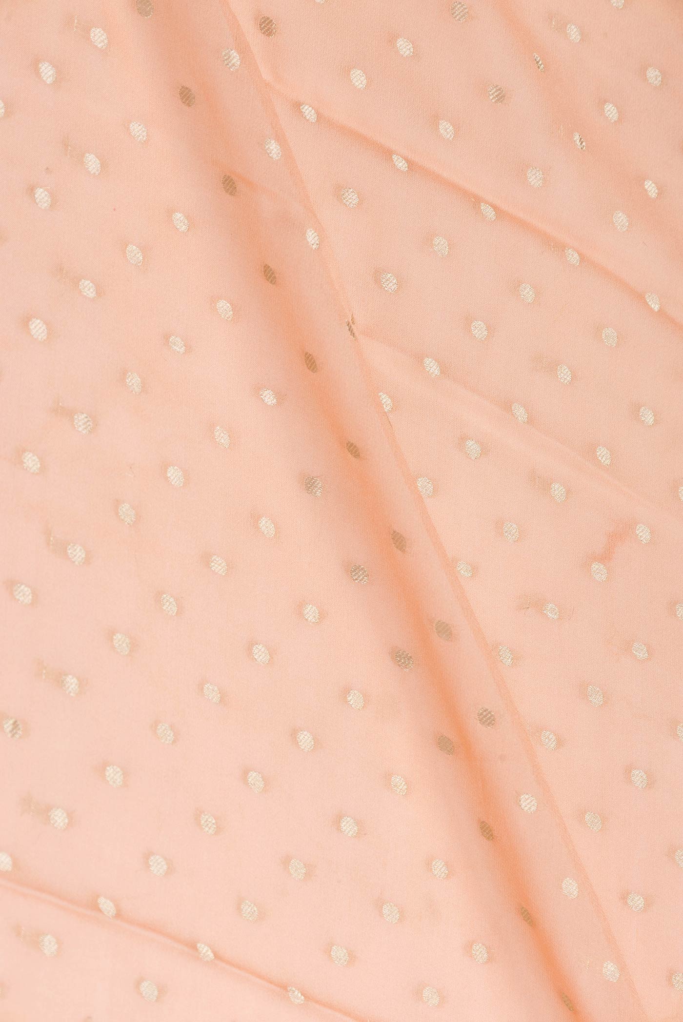 Close up of Golden Peach Dual Tone Mysore Georgette Saree with Zari Butta on the body and Zari Border displaying folds