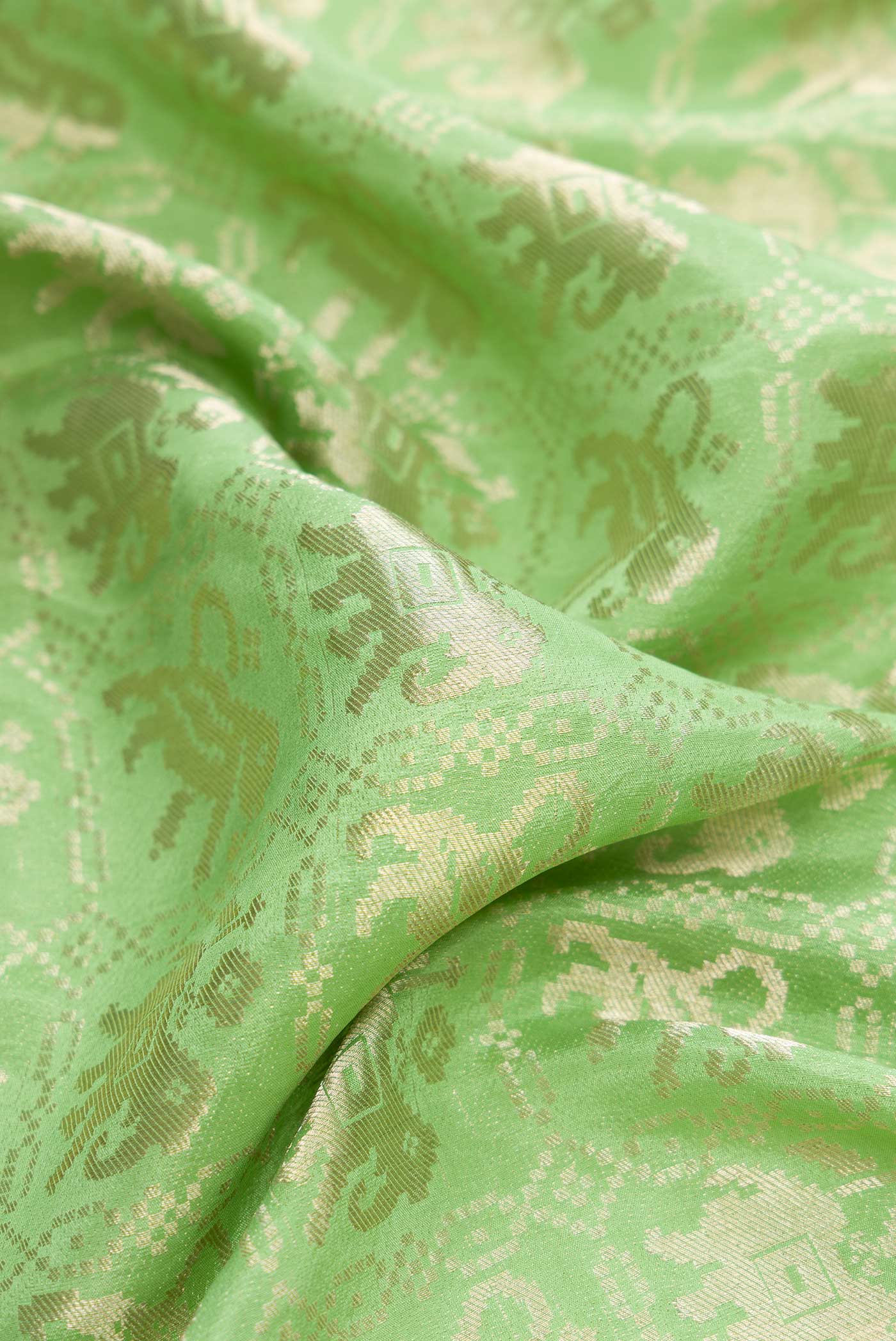 Close up of Pista Green Dual Tone Banarasi Georgette Saree with Zari Brocade on the body and Zari Border.  displaying folds