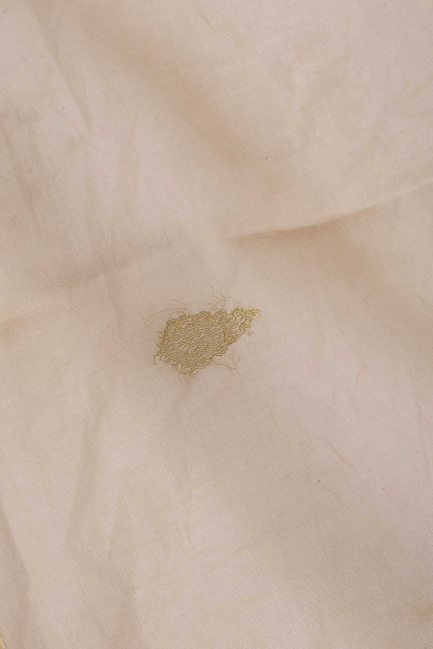 Close up of Peach Dual Tone Organza Silk Saree with Zari Butta on the body and Zari Border.  displaying folds