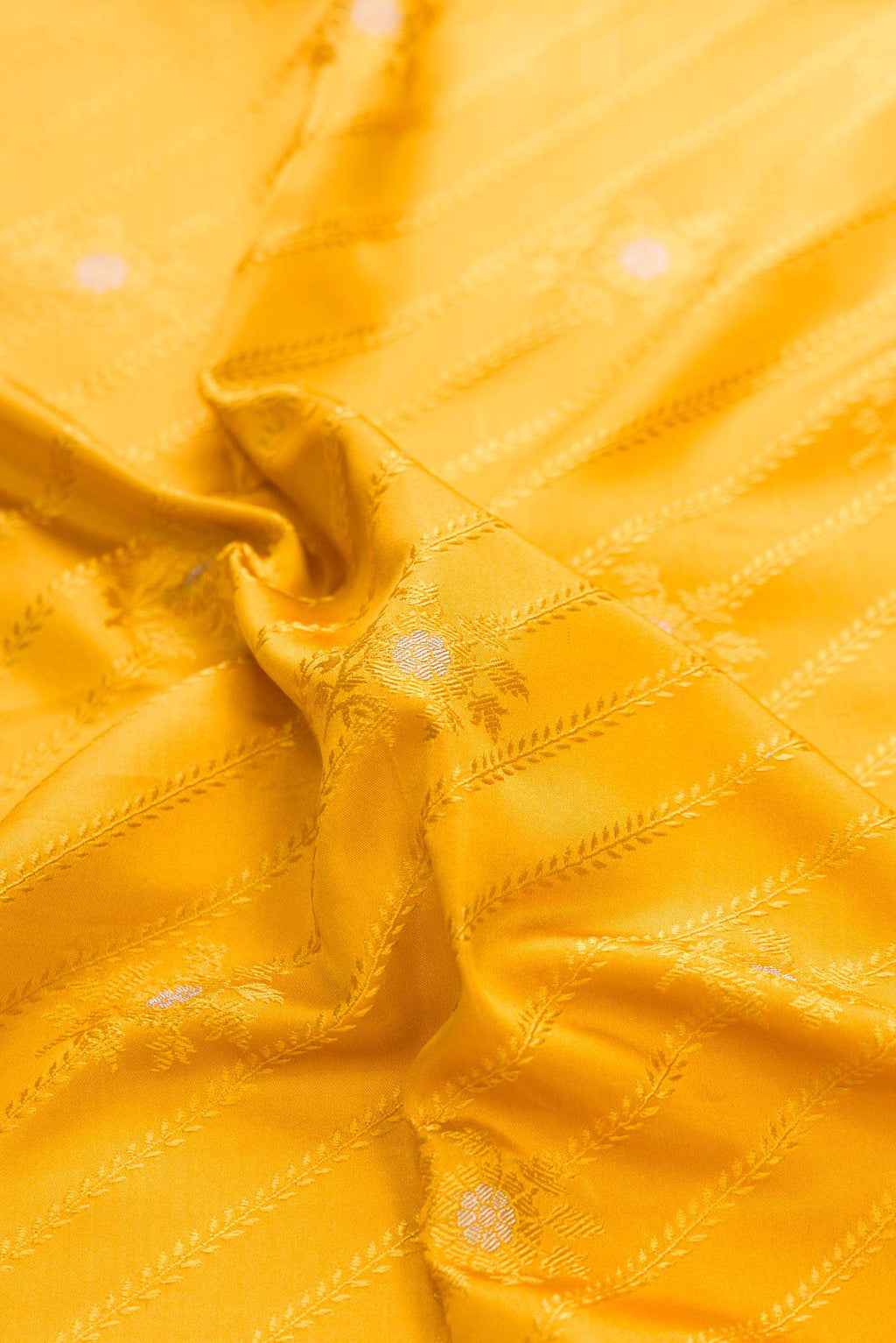 Close up of Pure Silk Pure Zari Mustard Dual Tone Banarasi Saree with Jacquard With Zari Butta on the body and Zari Border displaying folds
