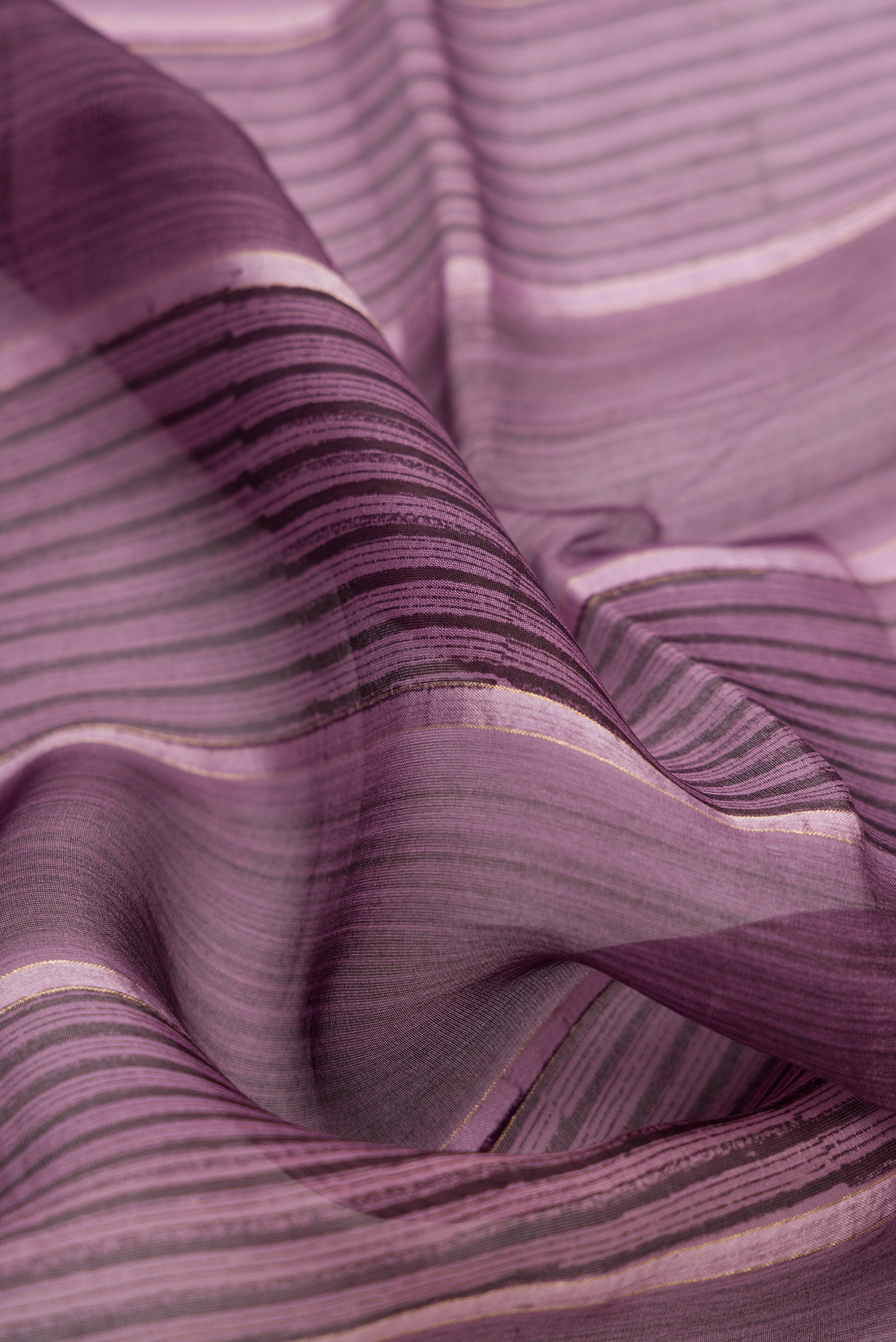 Close up of Burgundy Dual Tone Organza Silk Saree with Printed design on the body and Zari Border.  displaying folds