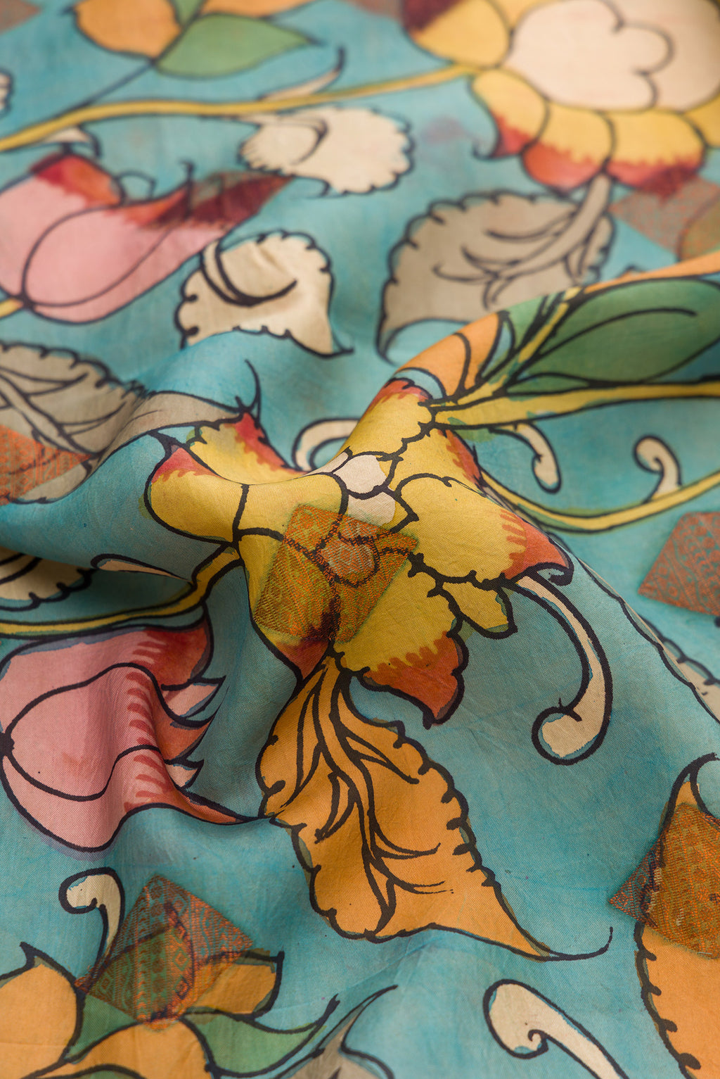 Close up of Blue Dual Tone Kanchipuram Silk Saree with kalamkari Print on the body and Zari Border.  displaying folds