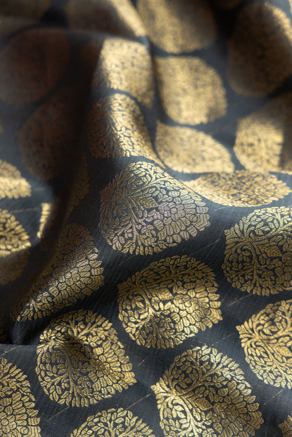 Close up of Grey Dual Tone Kanchipuram Silk Saree with Zari Brocade on the body and Zari Border.  displaying folds