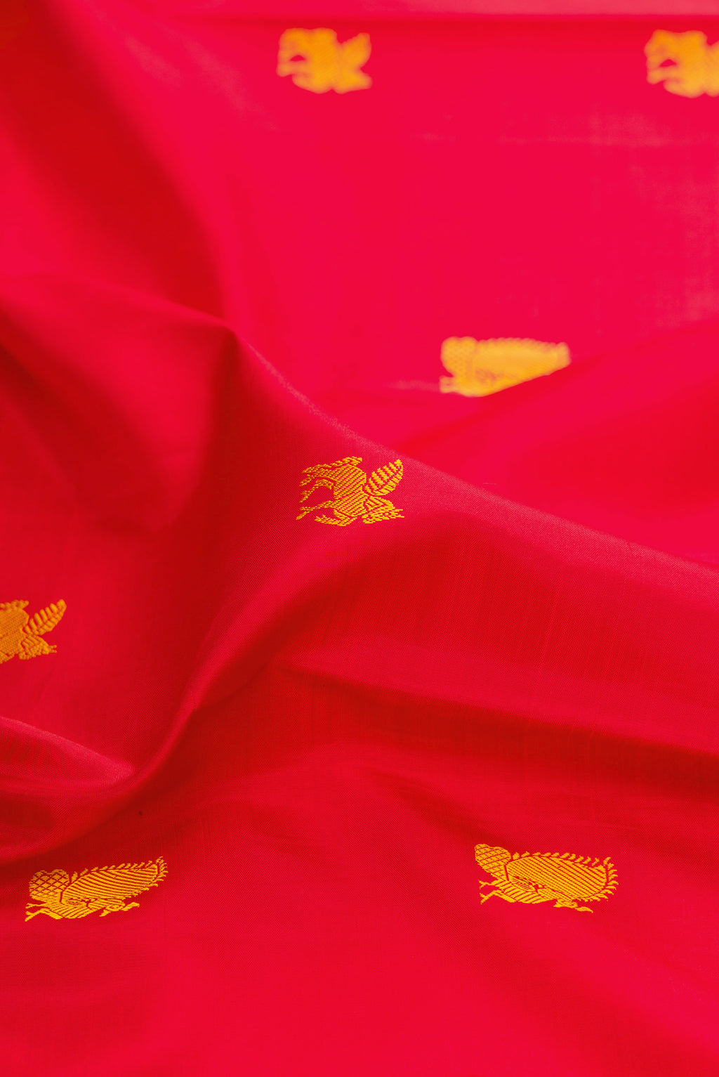 Close up of Red Kanjivaram Silk Saree with Thread Butta on the body and Thread Border.  displaying folds
