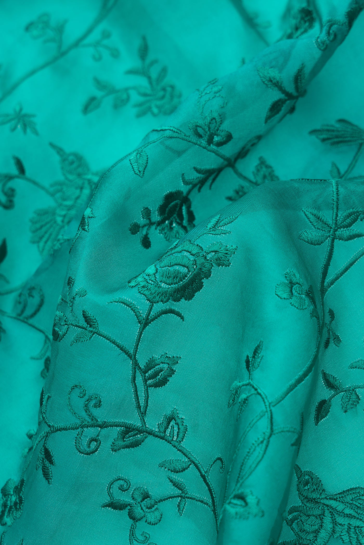 Close up of Green Dual Tone Organza Silk Saree with Embroidery on the body and Embroidery Border.  displaying folds