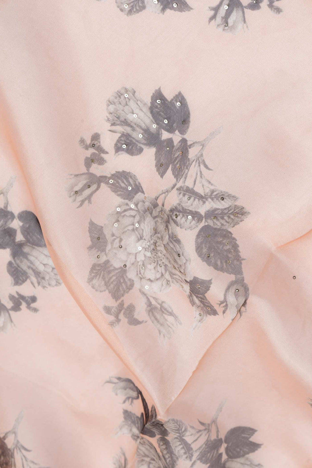 Close up of Peach Dual Tone Organza Silk Saree with Zari Butta on the body and Zari Border.  displaying folds