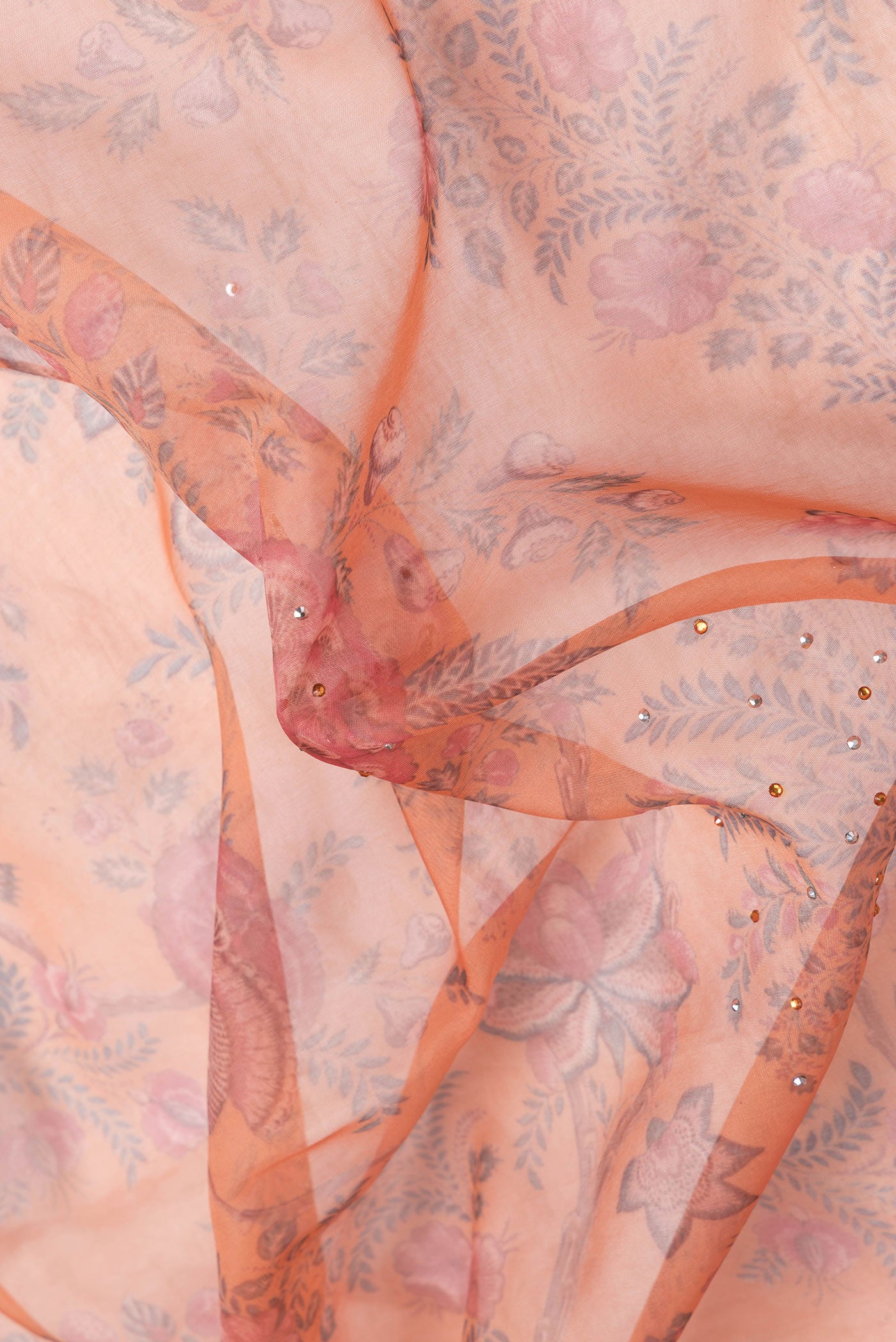 Close up of Orange Dual Tone Organza Silk Saree with Printed design on the body and Embroidery Border.  displaying folds