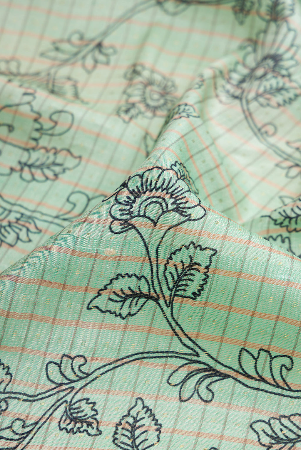 Close up of Sea Green Dual Tone Tussar Silk Saree with Printed design on the body and Fancy Border.  displaying folds