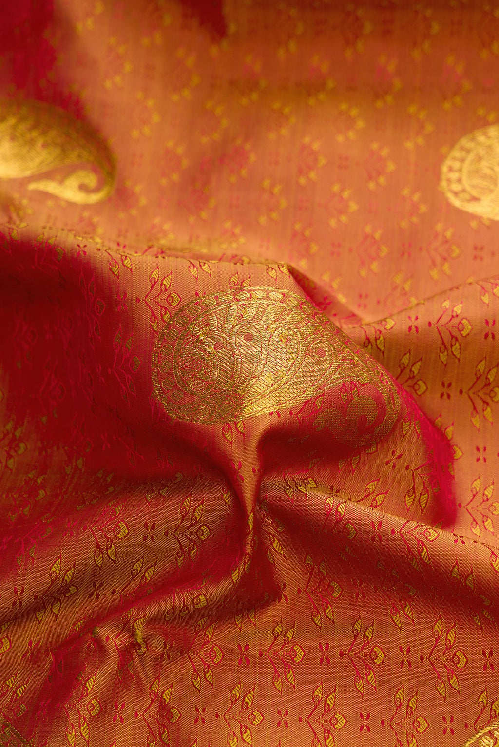 Close up of Bronze Dual Tone Kanchipuram Silk Saree with Jacquard With Zari Butta on the body and Zari Border.  displaying folds