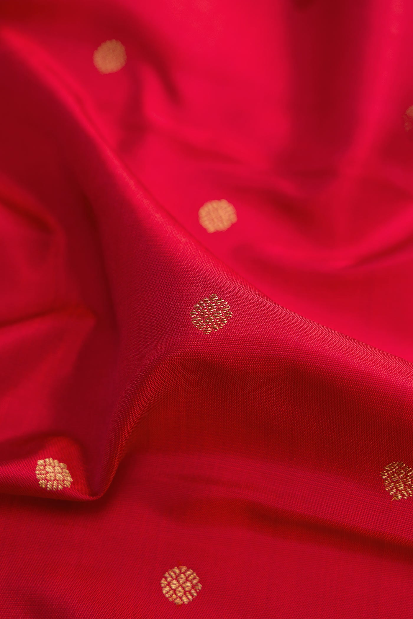 Close up of Pure Silk Pure Zari Red Dual Tone Kanchipuram Saree with Zari Butta on the body and Zari Border displaying folds