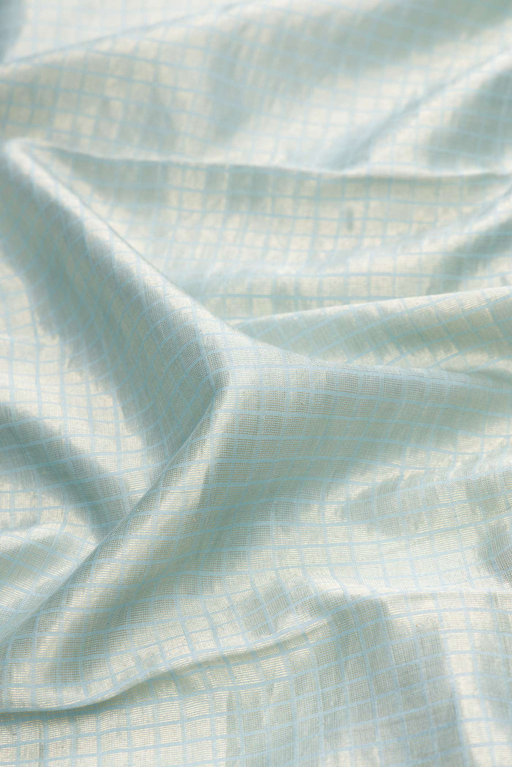 Close up of Maya Blue Dual Tone Tussar Silk Saree with Zari Brocade on the body and Embroidery Border.  displaying folds