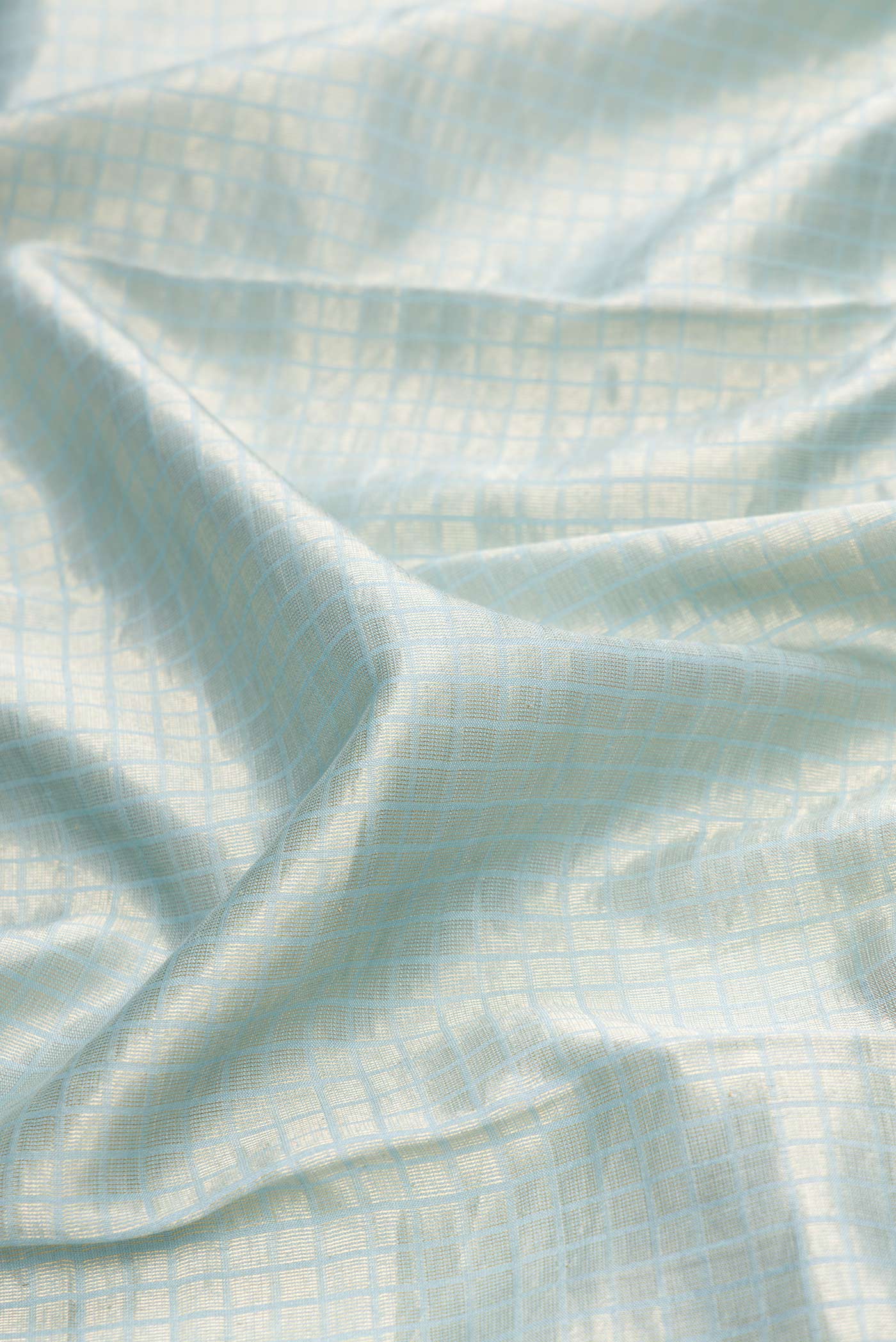 Close up of Maya Blue Dual Tone Tussar Silk Saree with Zari Brocade on the body and Embroidery Border.  displaying folds