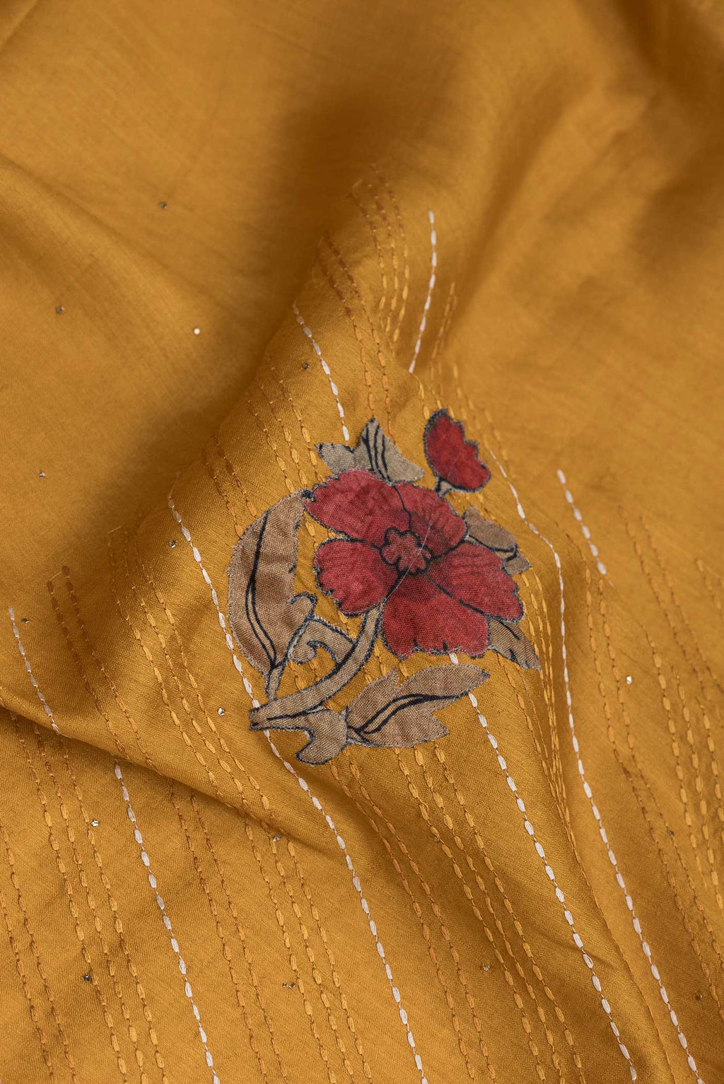 Close up of Mustard Tussar Silk Saree with Embroidery on the body and Embroidery Border displaying folds