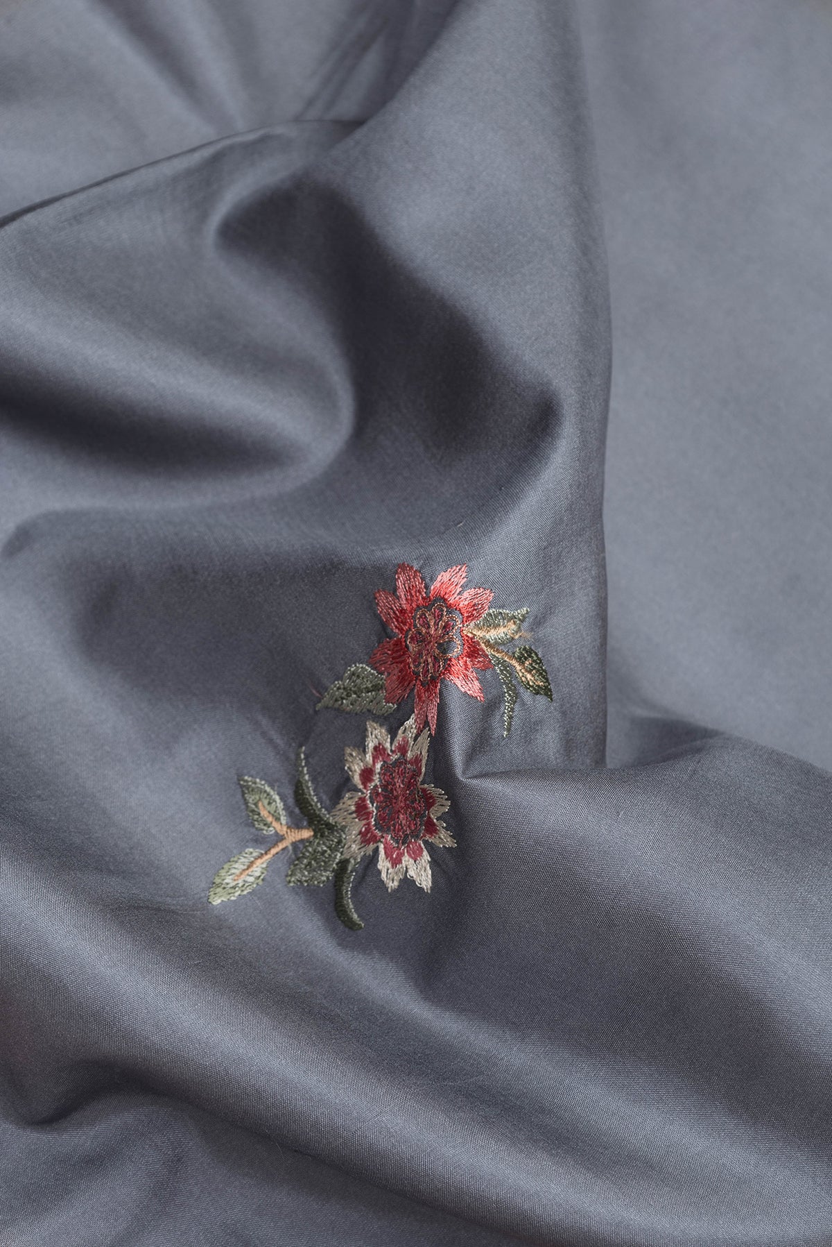 Close up of Grey Dual Tone Kanchipuram Silk Saree with Embroidery on the body and Zari Border.  displaying folds