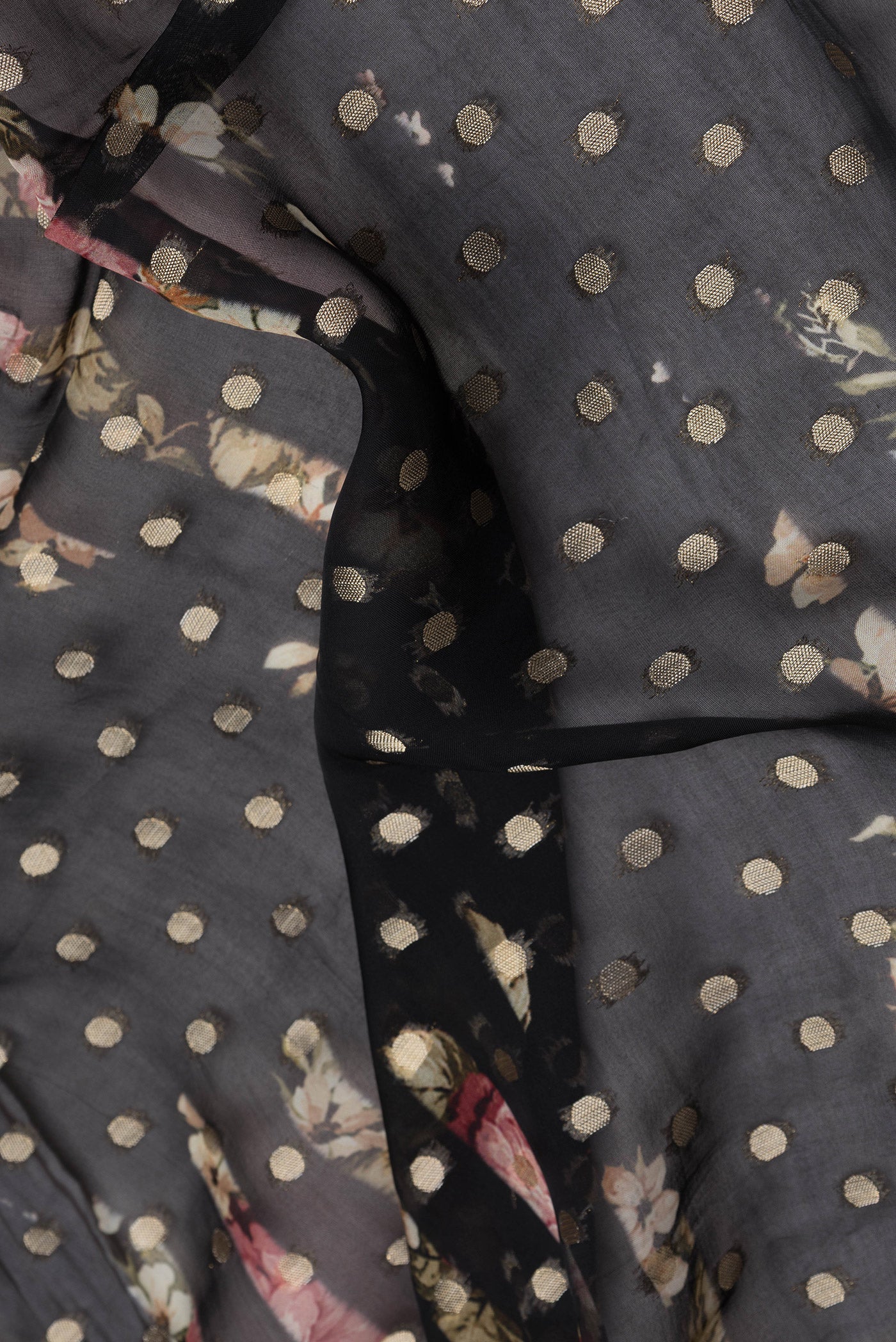 Close up of Black Dual Tone Organza Silk Saree with Zari Butta on the body and Zari Border.  displaying folds