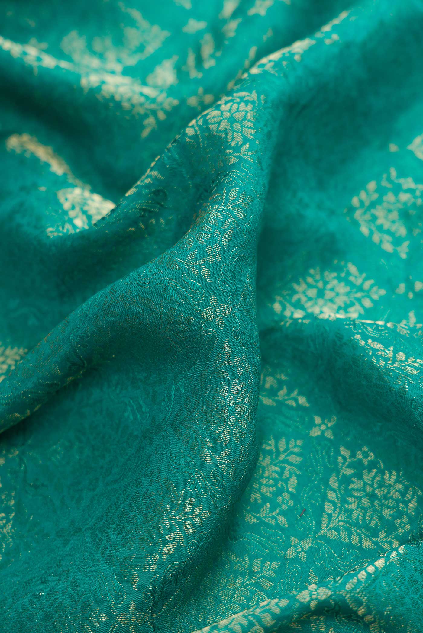 Close up of Peacock Blue Dual Tone Banarasi Georgette Saree with Zari Brocade on the body and Zari Border.  displaying folds