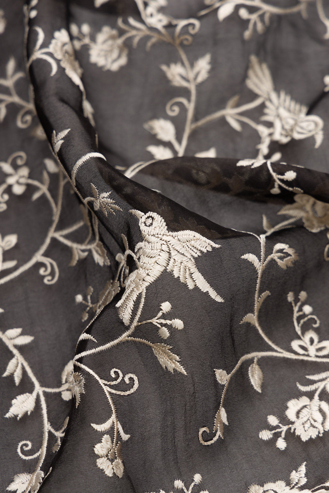 Close up of Black Dual Tone Organza Silk Saree with Embroidery on the body and Embroidery Border.  displaying folds