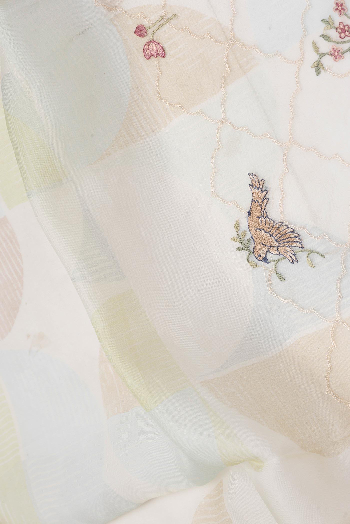 Close up of Beige Dual Tone Organza Silk Saree with Embroidery on the body and Fancy Border displaying folds