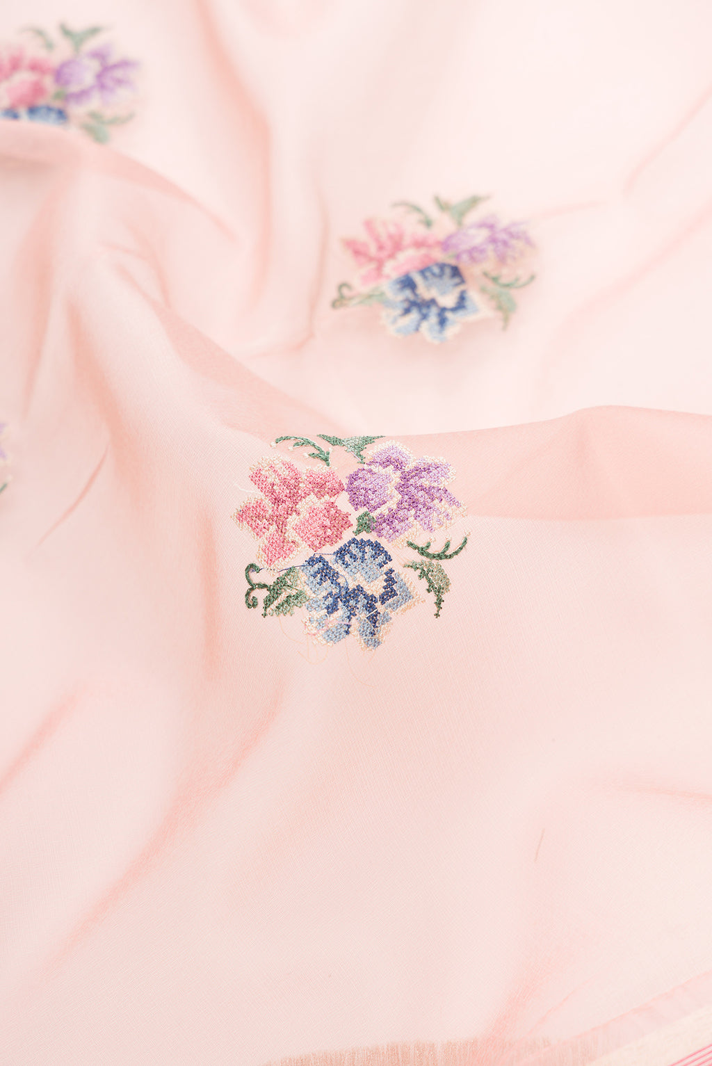 Close up of Rose pink Dual Tone Organza Silk Saree with Embroidery on the body and Paithani Border.  displaying folds