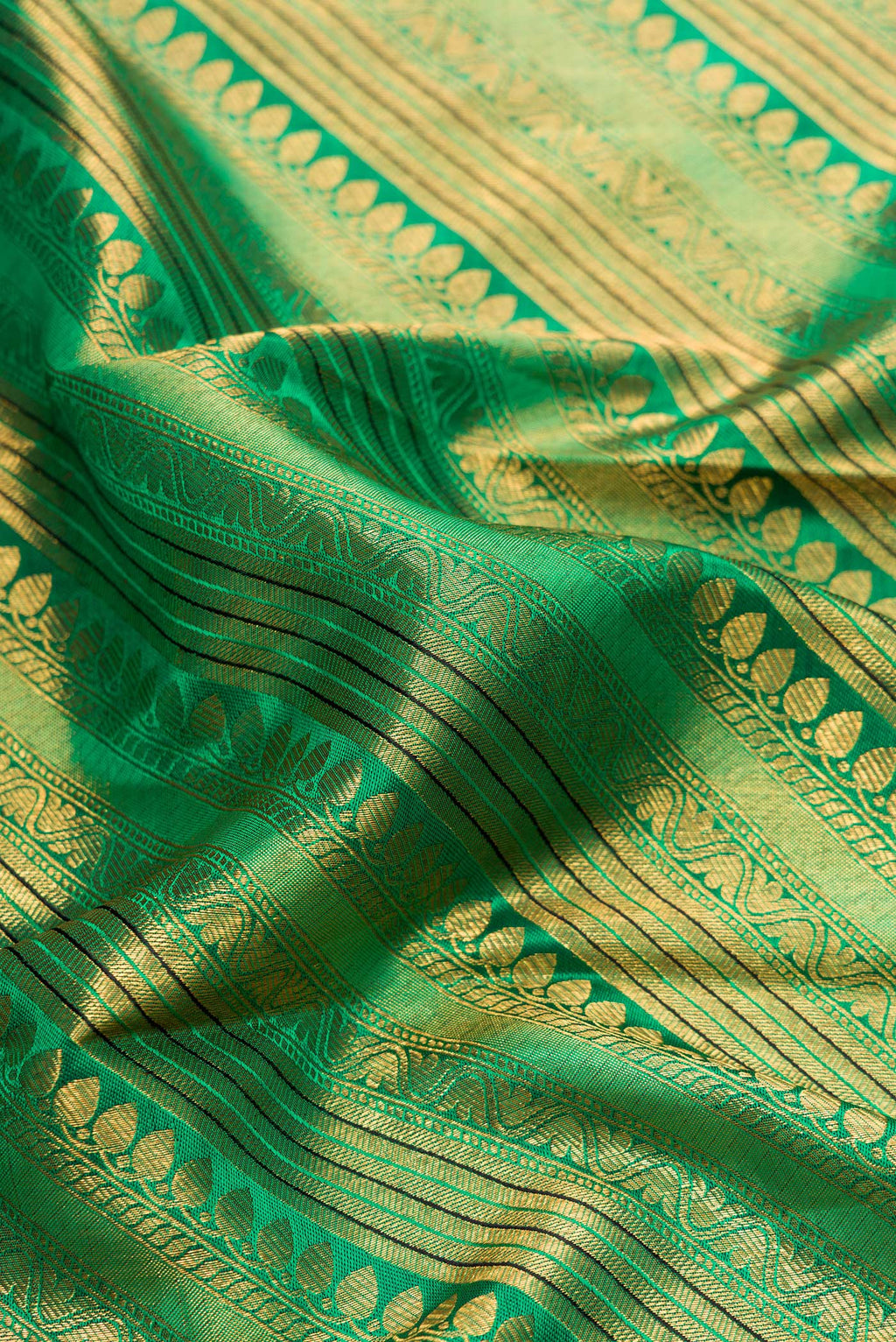 Close up of Green Dual Tone Kanchipuram Silk Saree with Zari Brocade on the body and Zari Border.  displaying folds