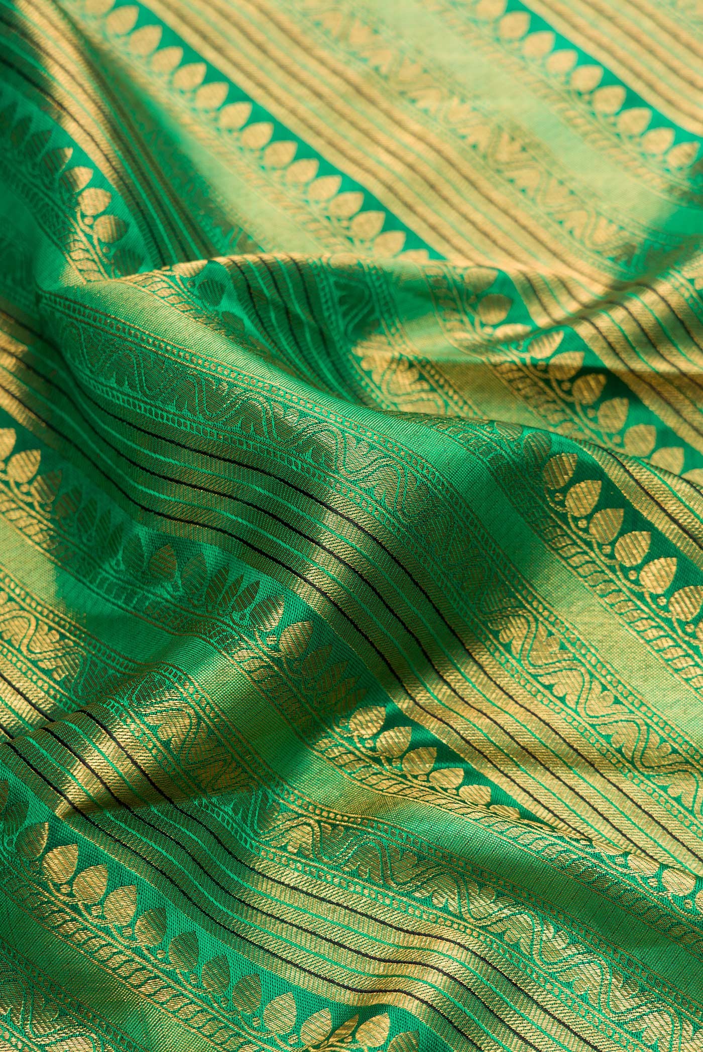 Close up of Green Dual Tone Kanchipuram Silk Saree with Zari Brocade on the body and Zari Border.  displaying folds
