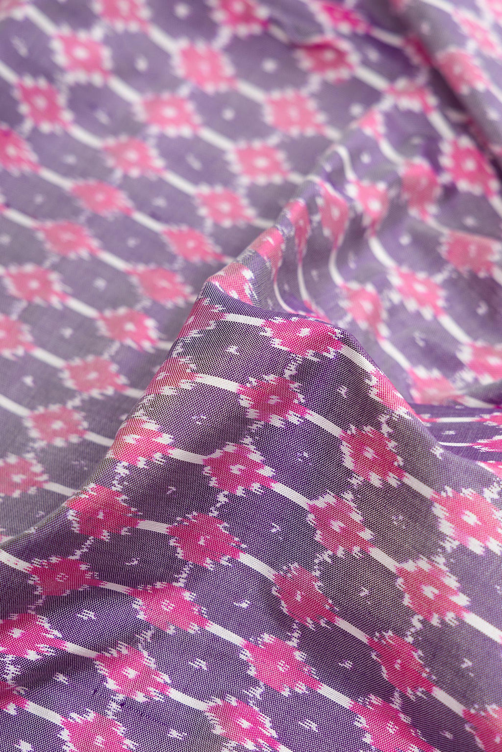 Close up of Grey Dual Tone Double Ikat Saree with Ikat Print on the body and Zari Border.  displaying folds