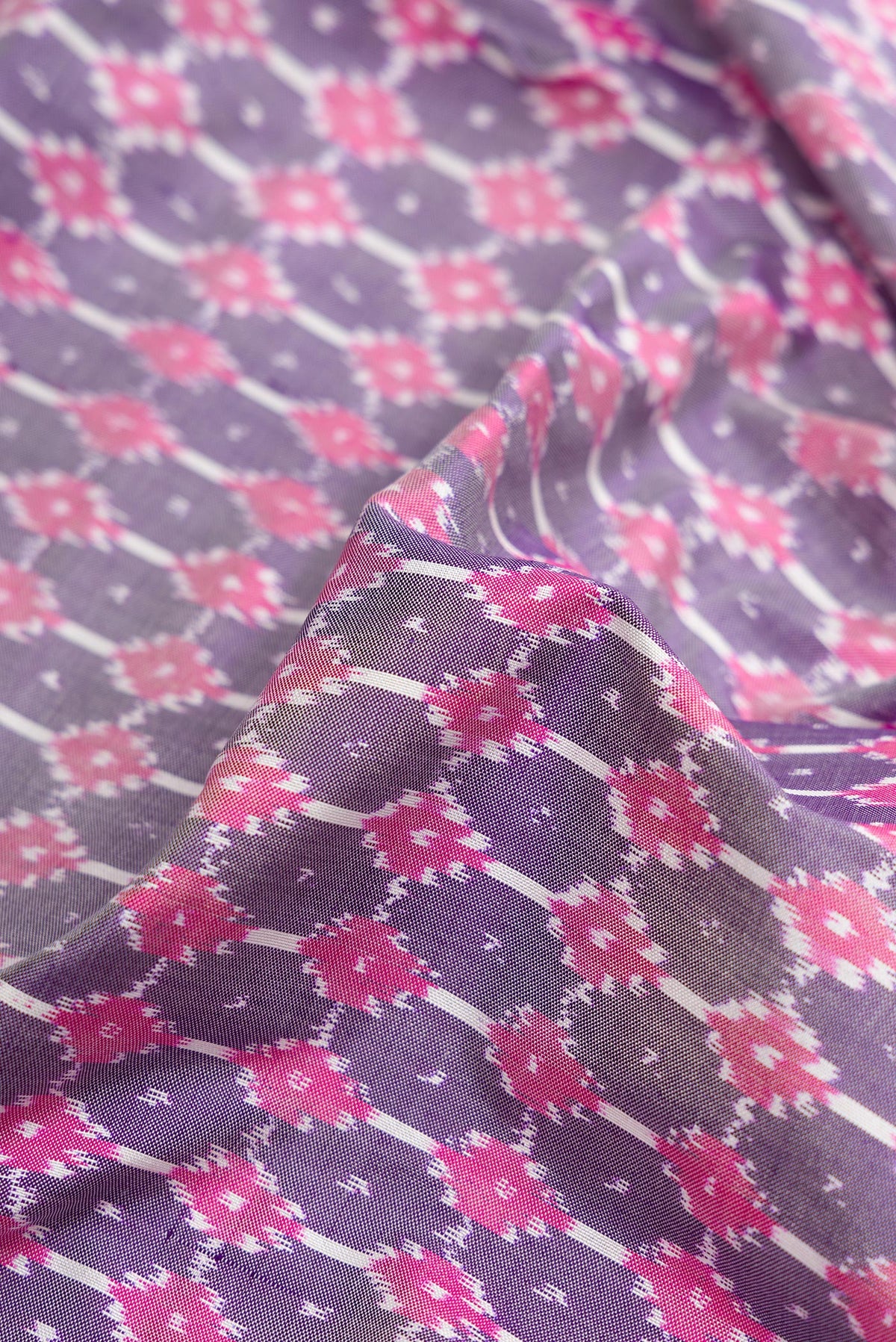 Close up of Grey Dual Tone Double Ikat Saree with Ikat Print on the body and Zari Border.  displaying folds