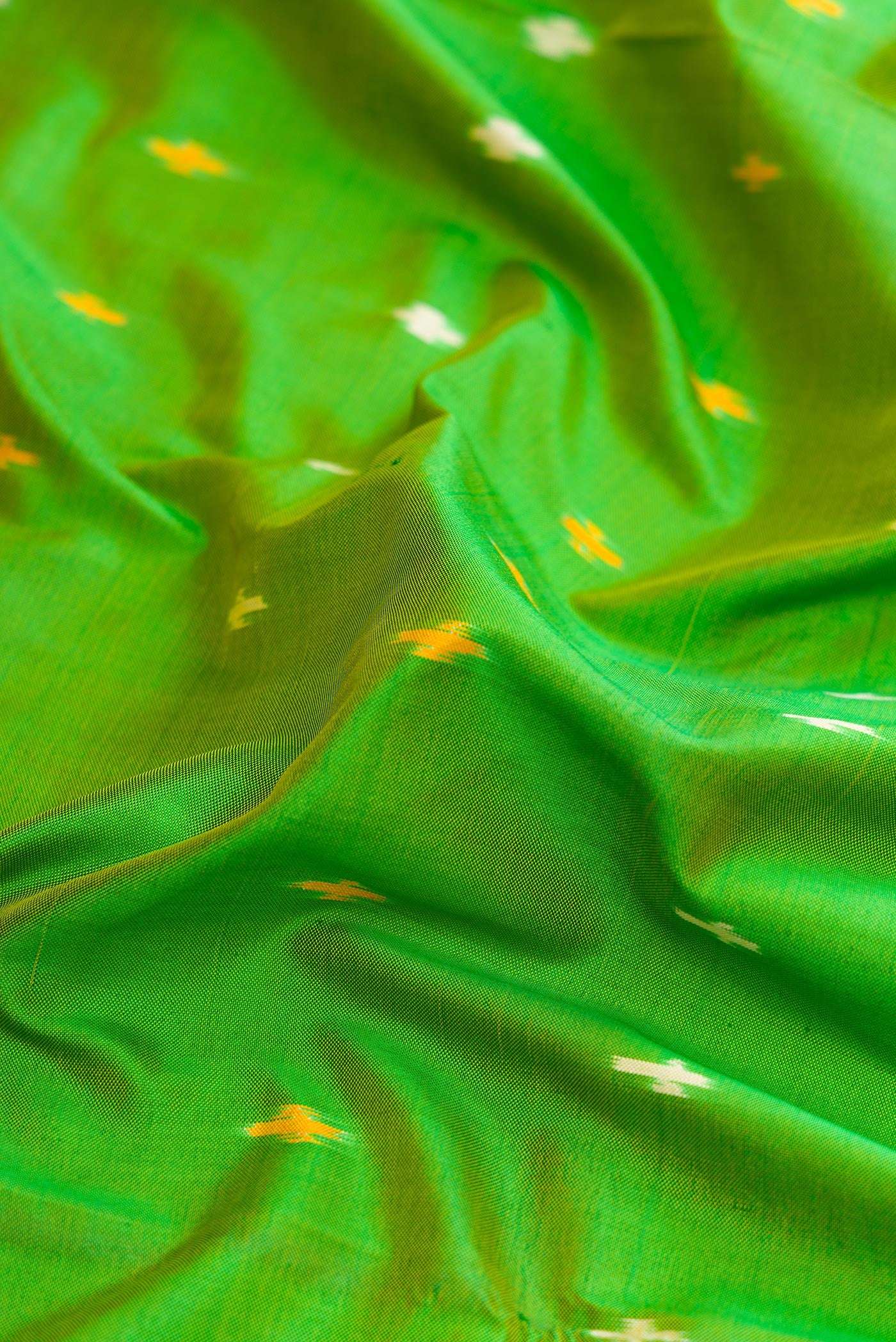 Close up of Parrot Green Dual Tone Double Ikat Saree with Ikat Print on the body and Ikat Border.  displaying folds