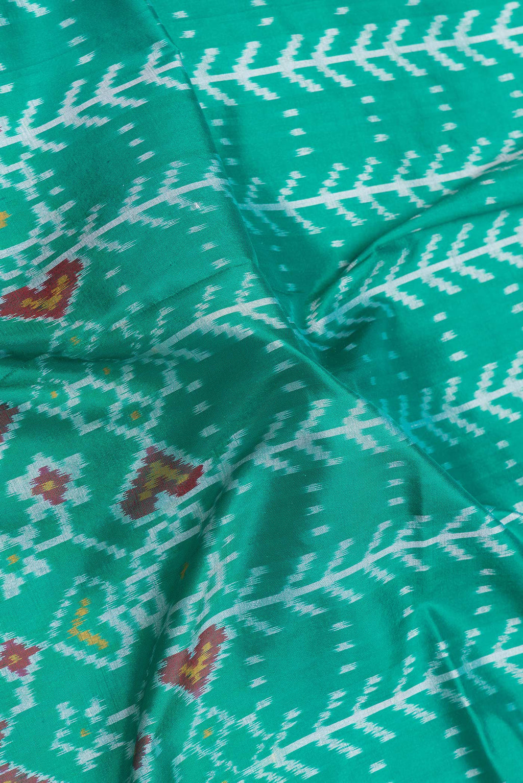 Close up of Sea Green Dual Tone Double Ikat Saree with Ikat Print on the body and Ikat Border.  displaying folds