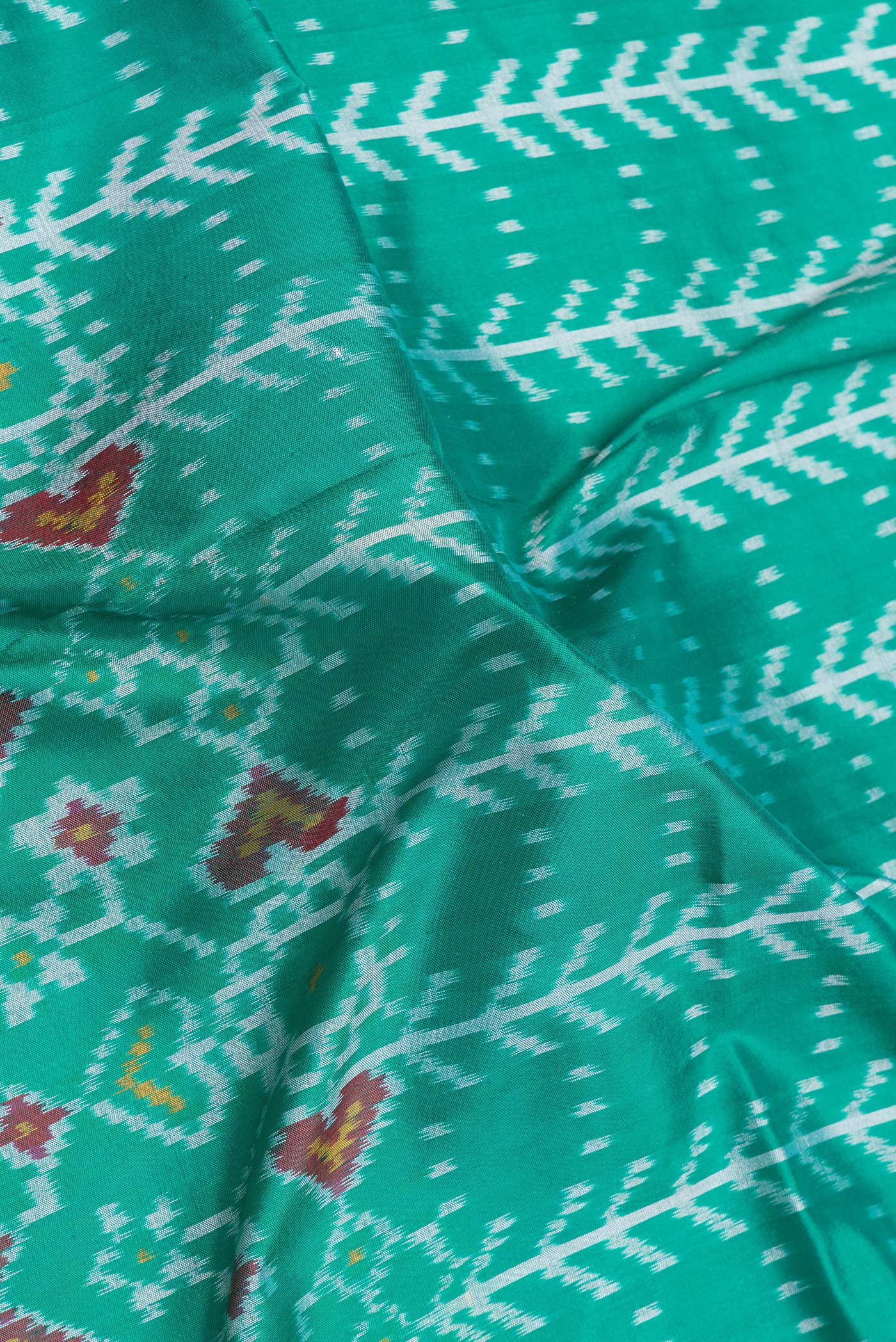 Close up of Sea Green Dual Tone Double Ikat Saree with Ikat Print on the body and Ikat Border.  displaying folds