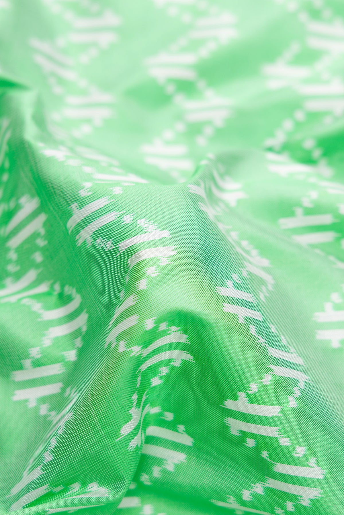 Close up of Pista Green Dual Tone Double Ikat Saree with Ikat Print on the body and Ikat Border.  displaying folds