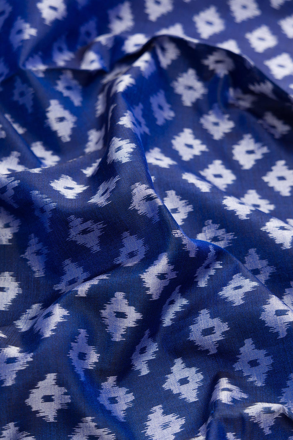 Close up of Royal Blue Dual Tone Double Ikat Saree with Ikat Print on the body and Plain Border.  displaying folds