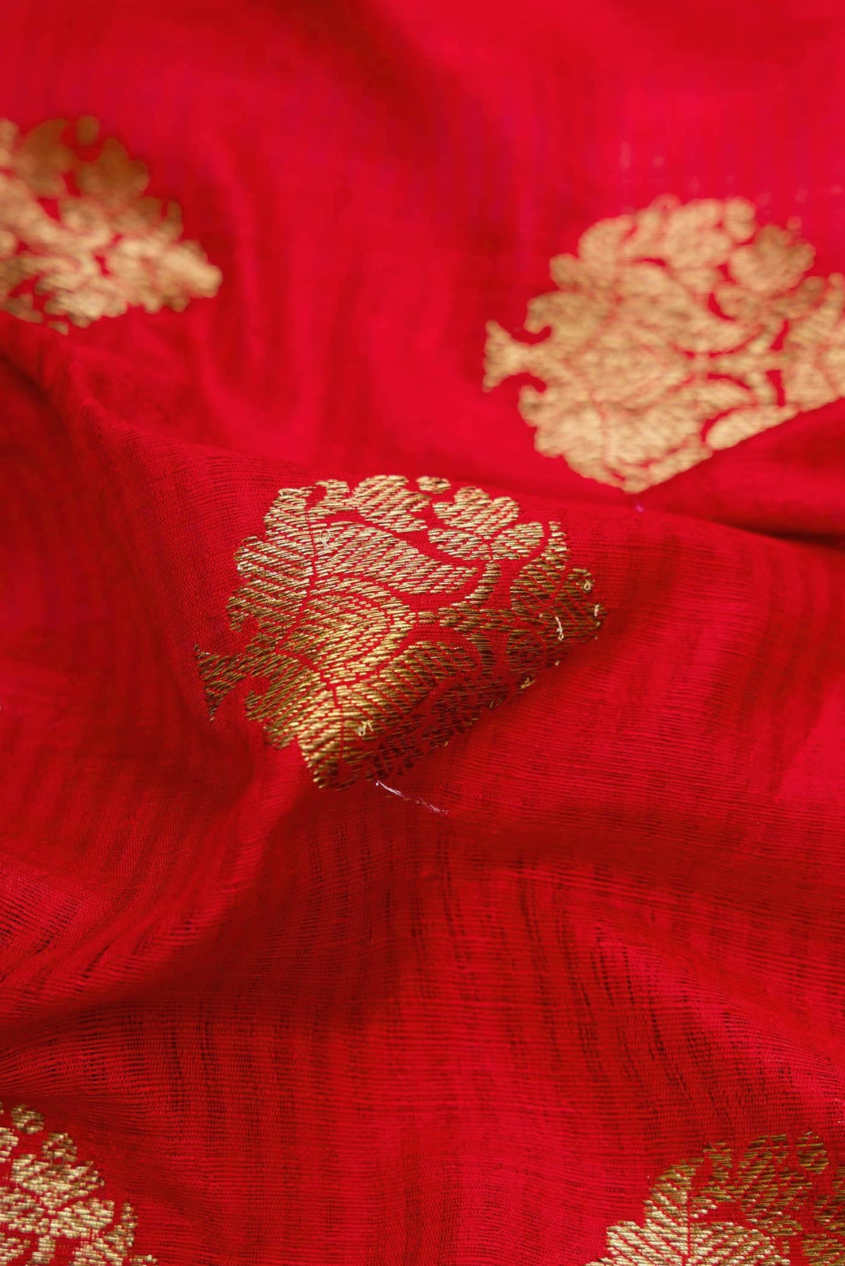 Close up of Red Banarasi Tussar Silk Saree with Zari Butta on the body and Zari Border displaying folds