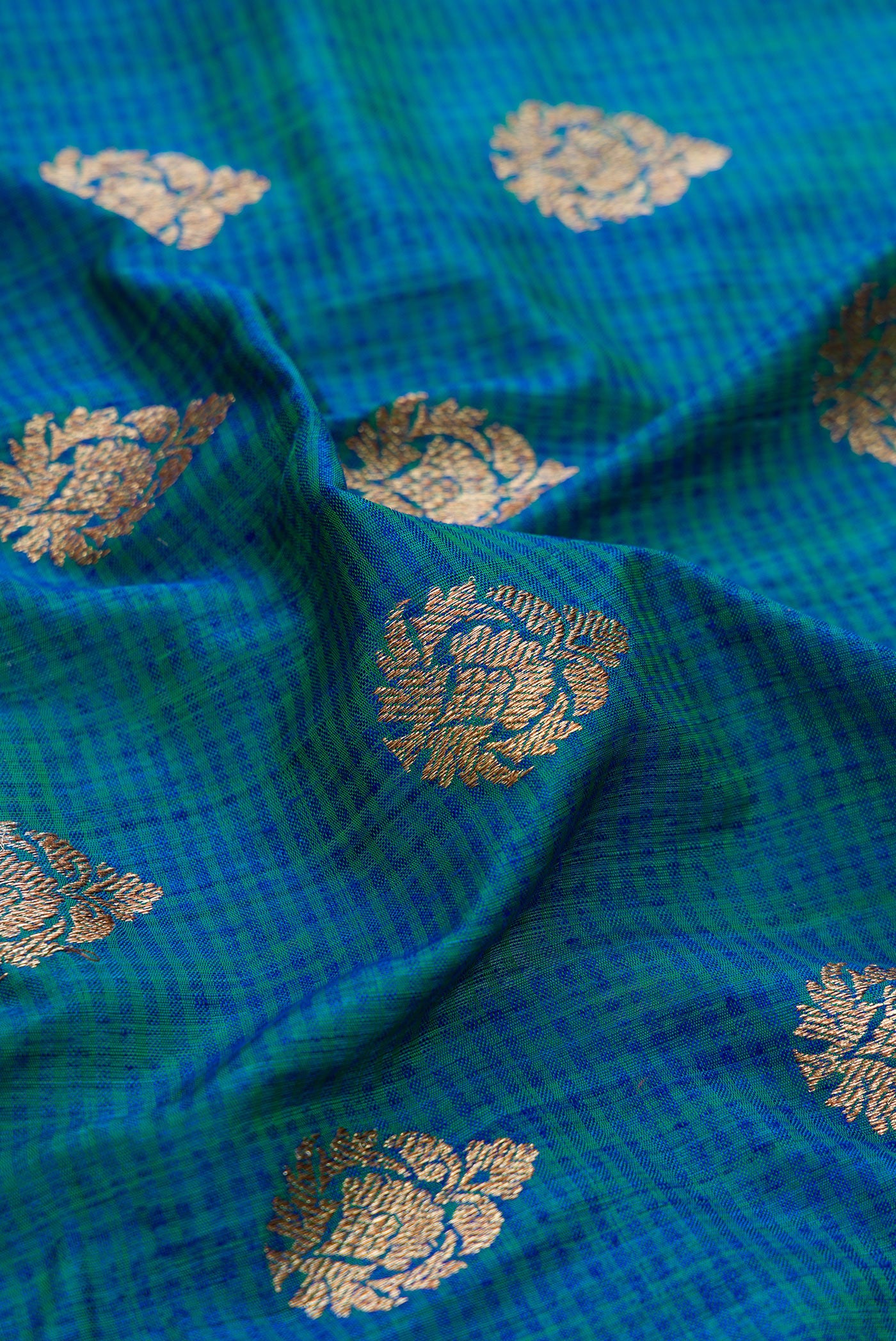 Close up of Peacock Blue Dual Tone Banarasi Silk Saree with Zari Butta on the body and Fancy Border.  displaying folds