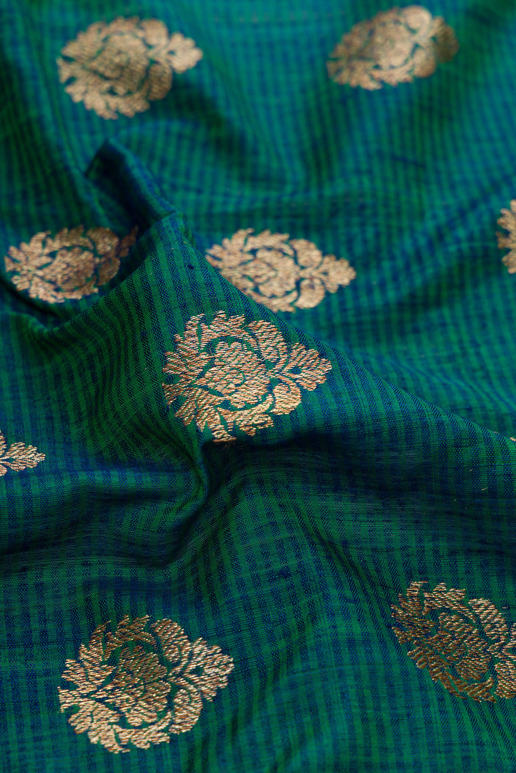 Close up of Green Dual Tone Banarasi Silk Saree with Zari Butta on the body and Fancy Border.  displaying folds