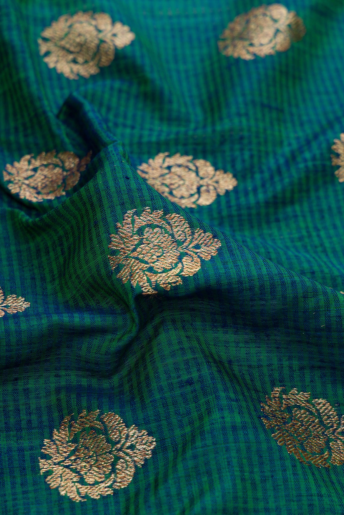 Close up of Green Dual Tone Banarasi Silk Saree with Zari Butta on the body and Fancy Border.  displaying folds