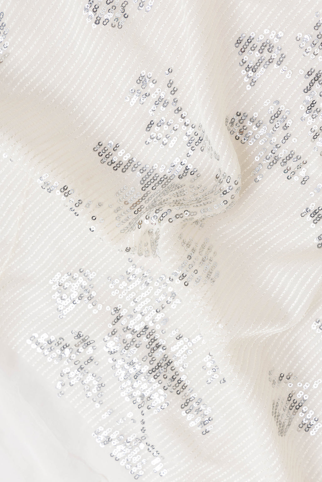 Close up of Beige Dual Tone Mysore Georgette Saree with Embroidery on the body and Without Border.  displaying folds