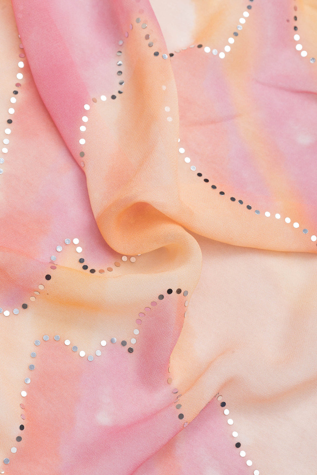 Close up of Peach Dual Tone Mysore Georgette Saree with Embroidery on the body and Embroidery Border.  displaying folds