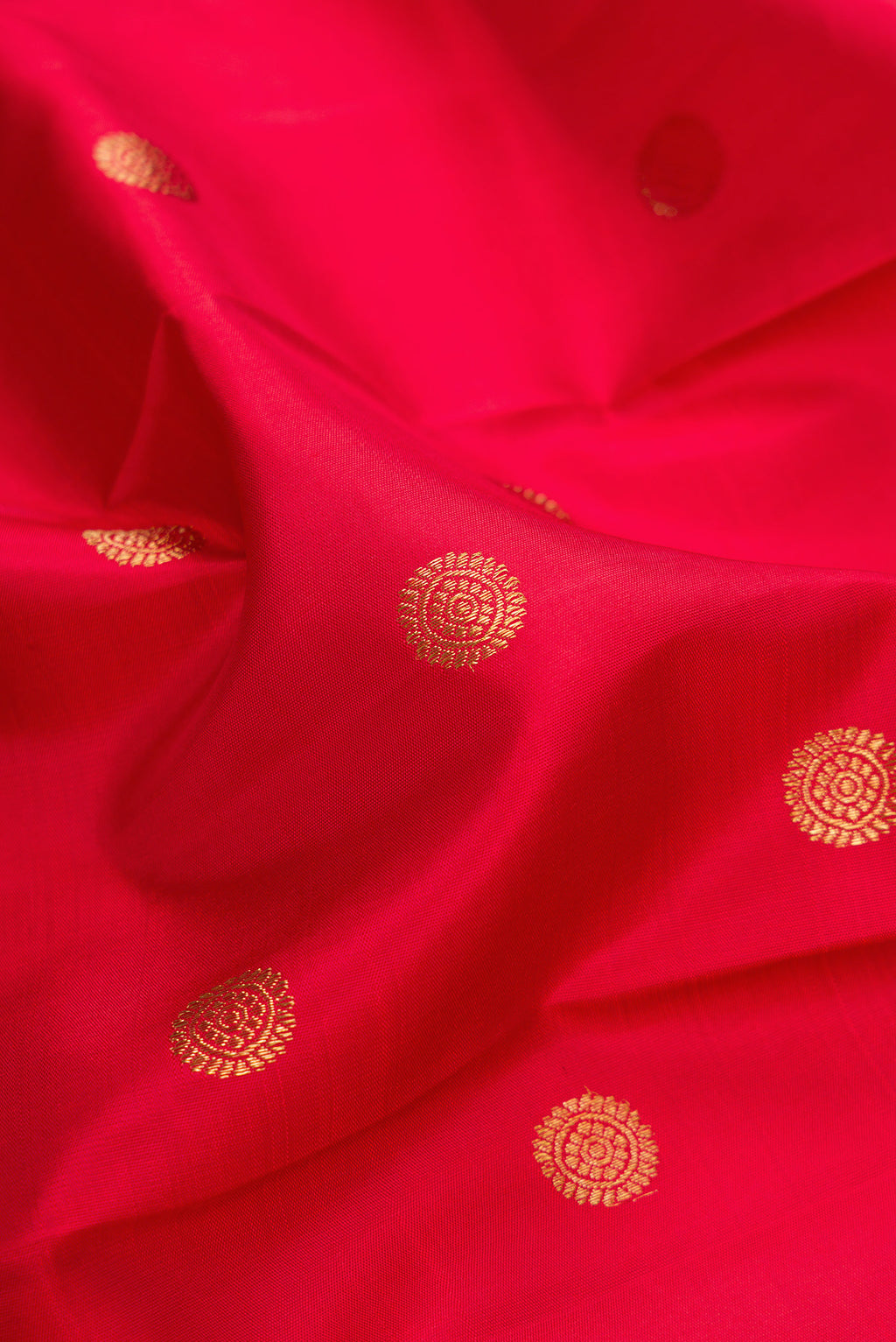 Close up of Pure Silk Pure Zari Red Kanjivaram Saree with Zari Butta on the body and Fancy Border.  displaying folds