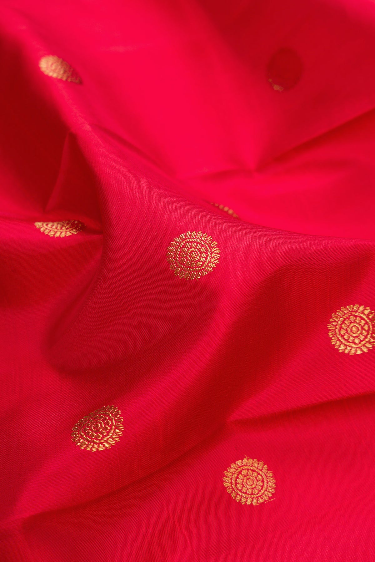Close up of Pure Silk Pure Zari Red Kanjivaram Saree with Zari Butta on the body and Fancy Border.  displaying folds