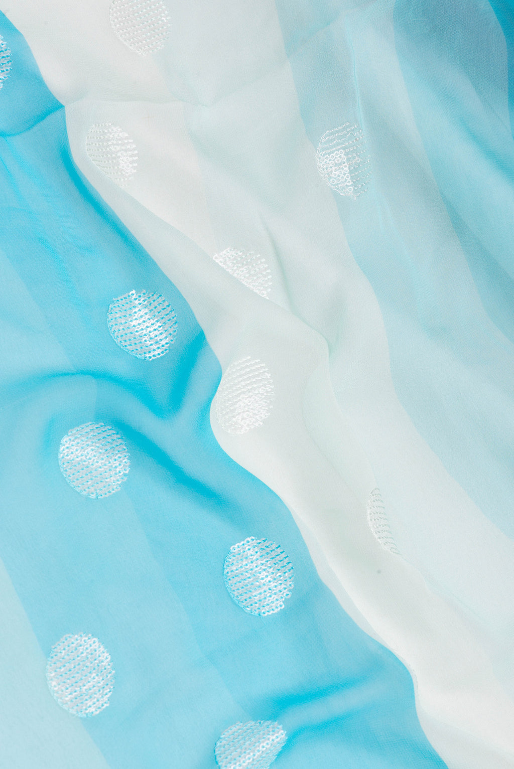 Close up of Sky Blue and Beige Color Georgette Saree with Embroidery on the body and Embroidery Border.  displaying folds