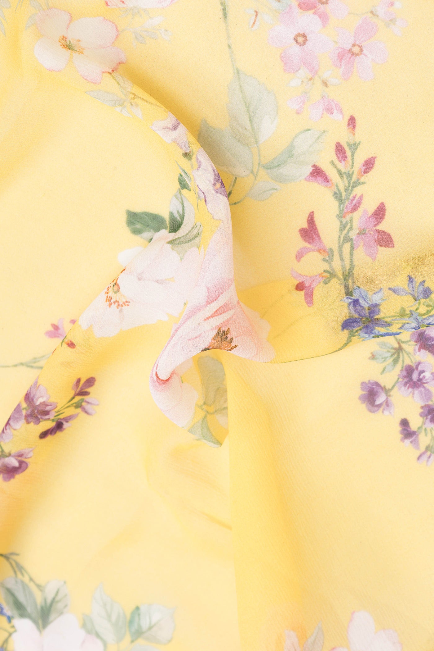 Close up of Yellow Mysore Chiffon Saree with Printed design on the body and Without Border.  displaying folds
