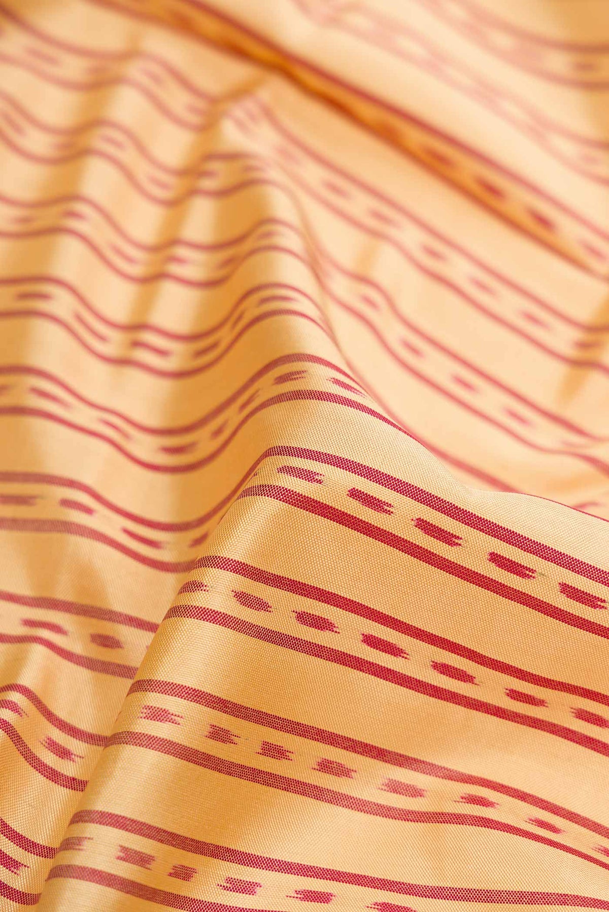 Close up of Sandal Dual Tone Rajkot Patola Silk Saree with Ikat Print on the body and Zari Border displaying folds