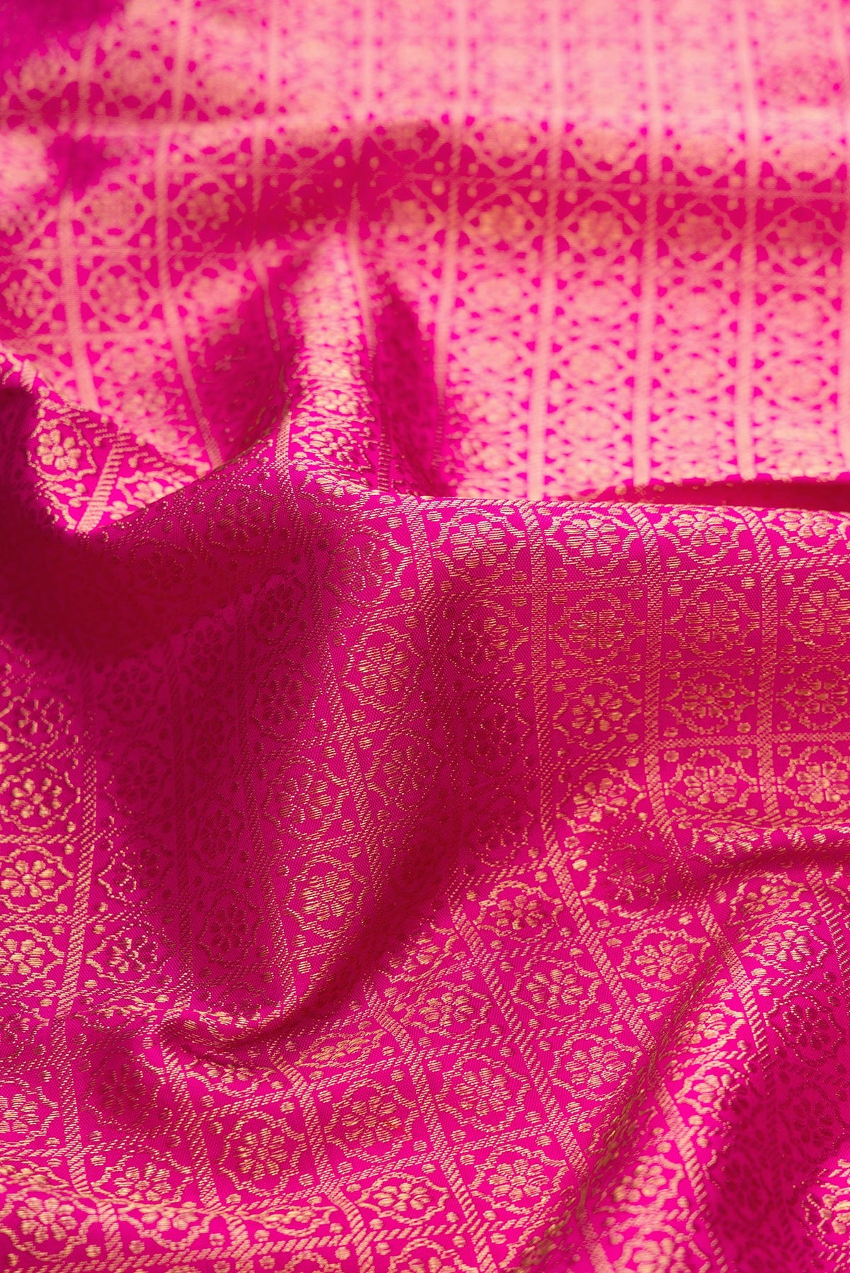 Close up of Dark Pink Dual Tone Kanjivaram Silk Saree with Zari Brocade on the body and Zari Border.  displaying folds