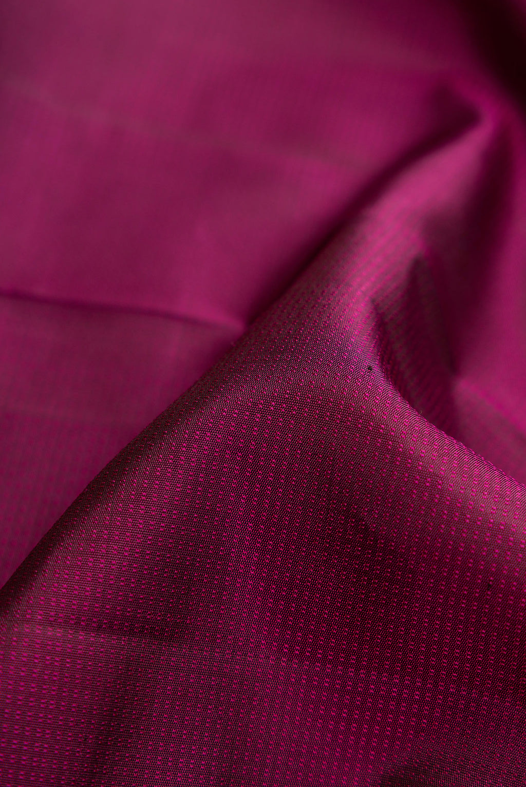 Close up of Magenta Dual Tone Kanchipuram Silk Saree with Jacquard design on the body and Thread Border.  displaying folds