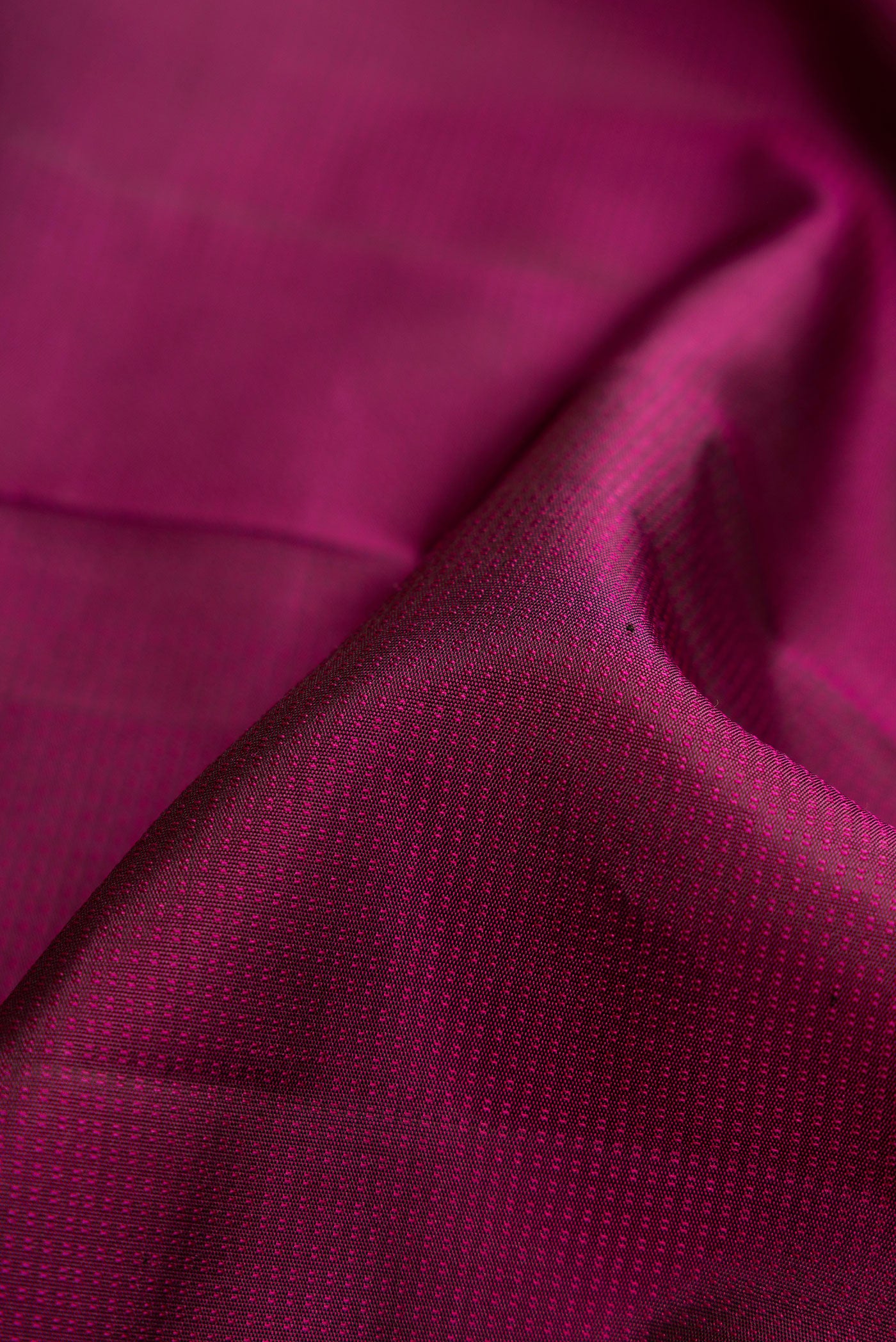 Close up of Magenta Dual Tone Kanchipuram Silk Saree with Jacquard design on the body and Thread Border.  displaying folds